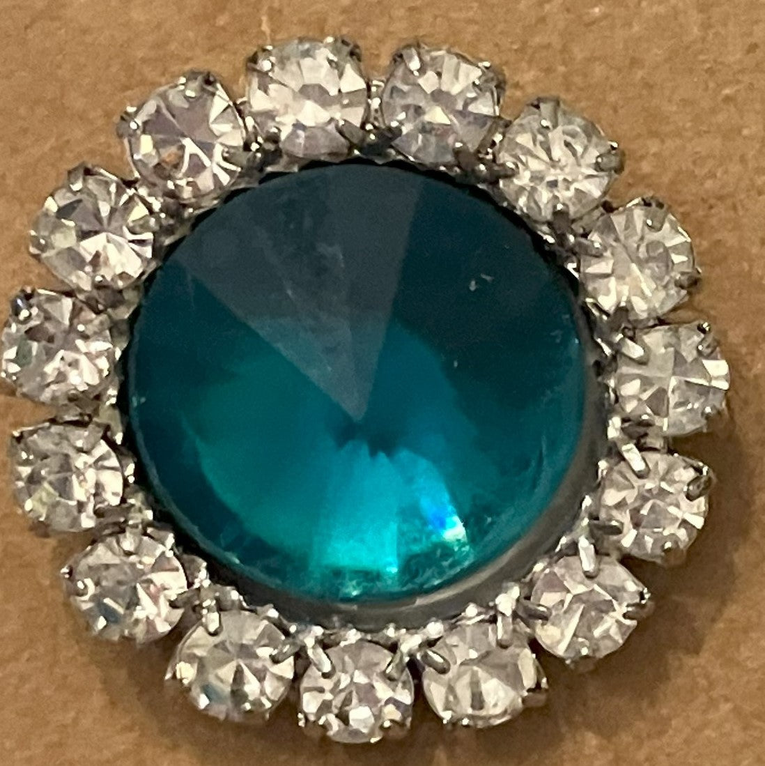 Pair of round, teal-colored central gemstone earrings with halos