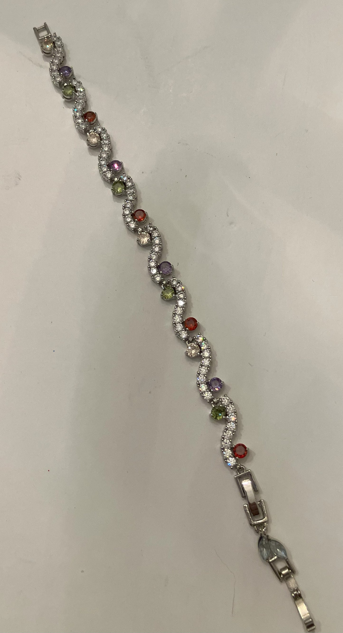 Interlocking link bracelet with clear gemstones and colored gemstone accents