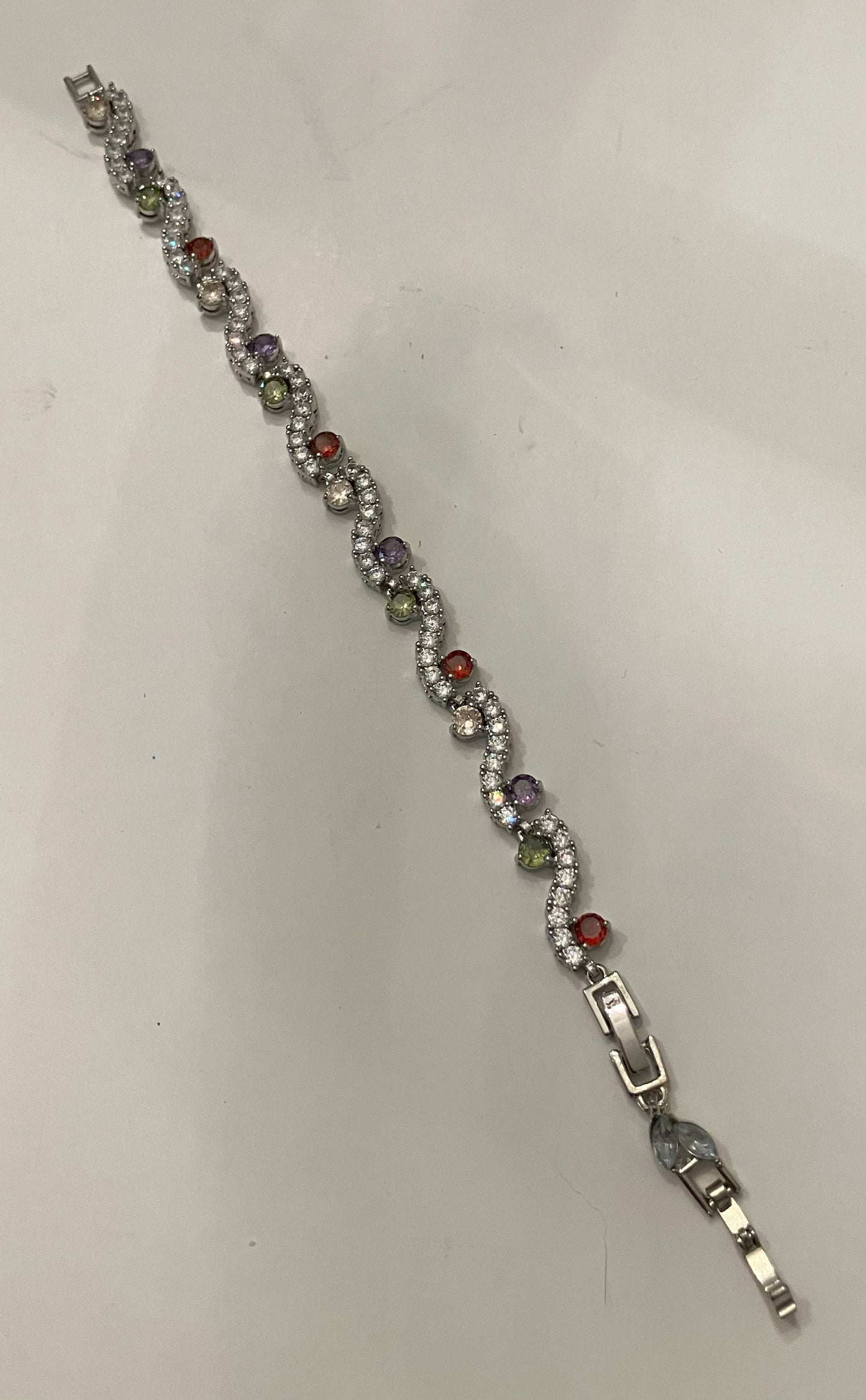 Interlocking link bracelet with clear gemstones and colored gemstone accents