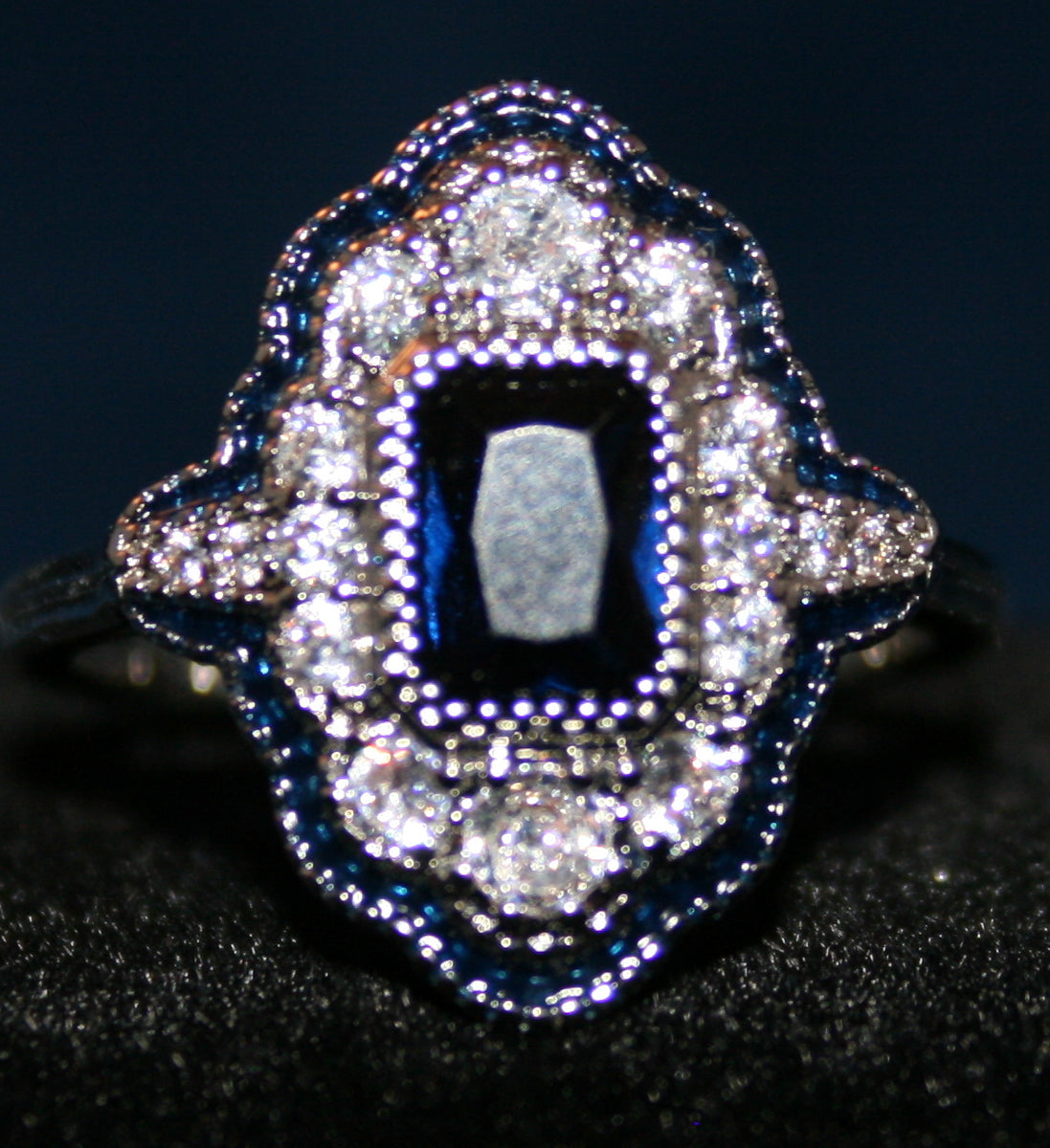 rectangular blue stone surrounded by clear stones