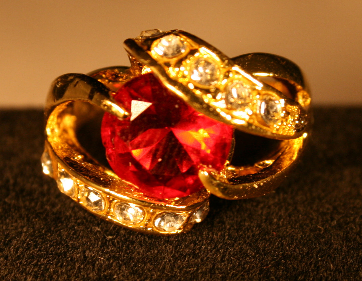 Large red gemstone in a twisted setting with clear stones