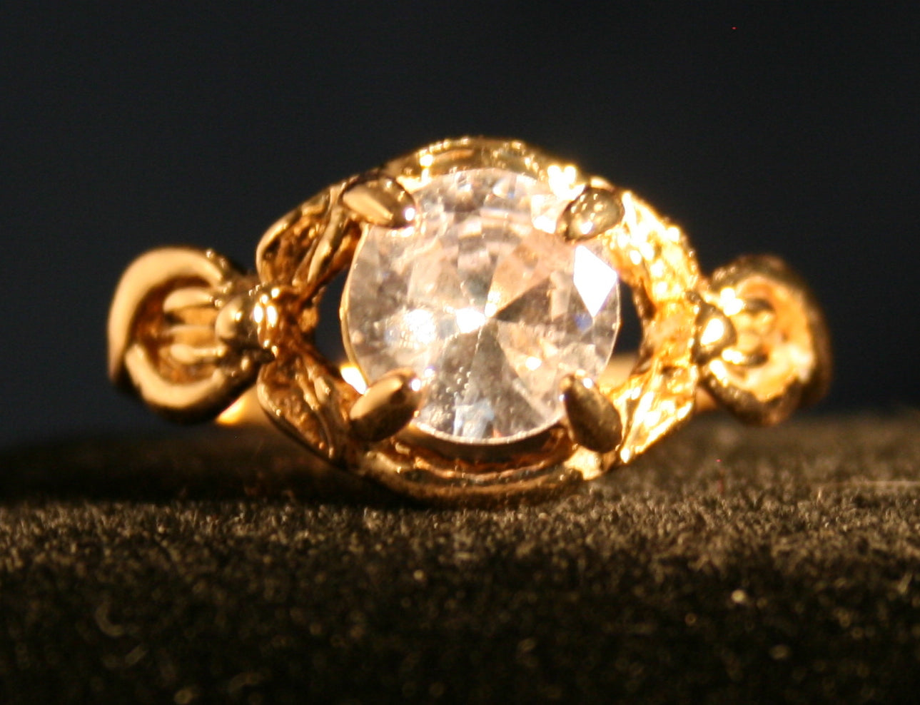 Round, clear gemstone in a gold setting