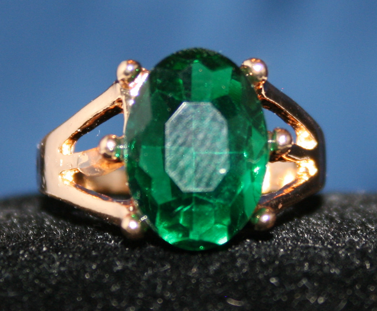 oval-shaped emerald green gemstone set in a gold band