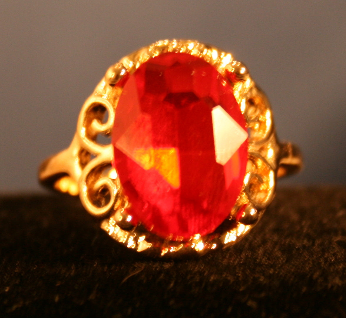 Intricate ornate setting with red oval gemstone