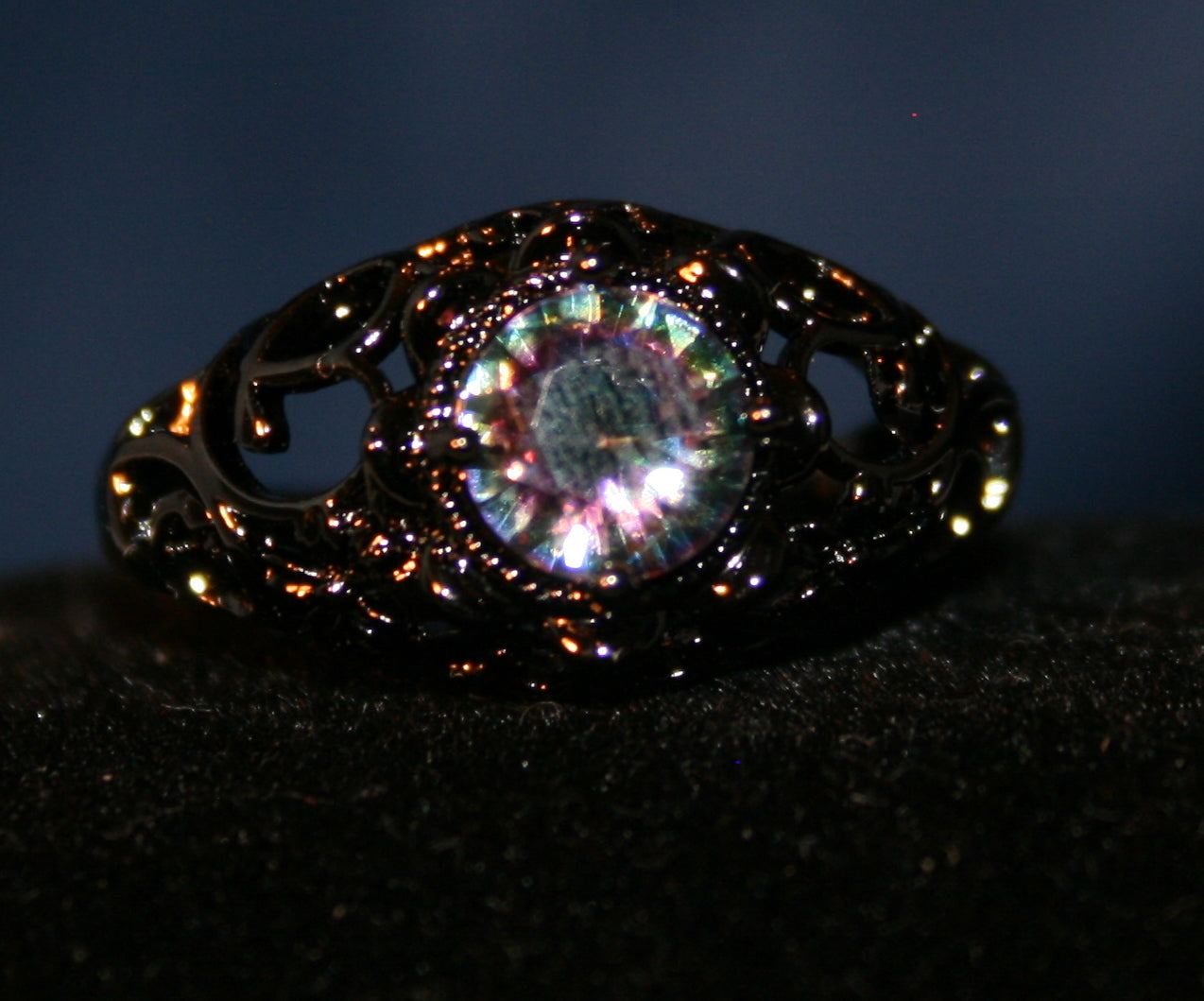 Black setting with a blue-green gemstone