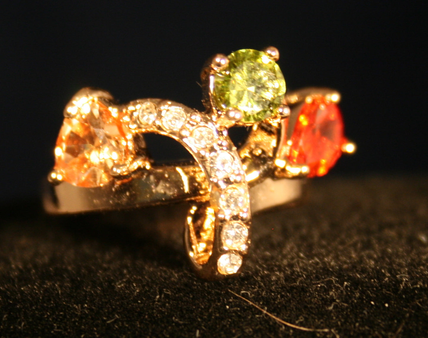 gold ring adorned with three prominent gemstones red green and yellow stones