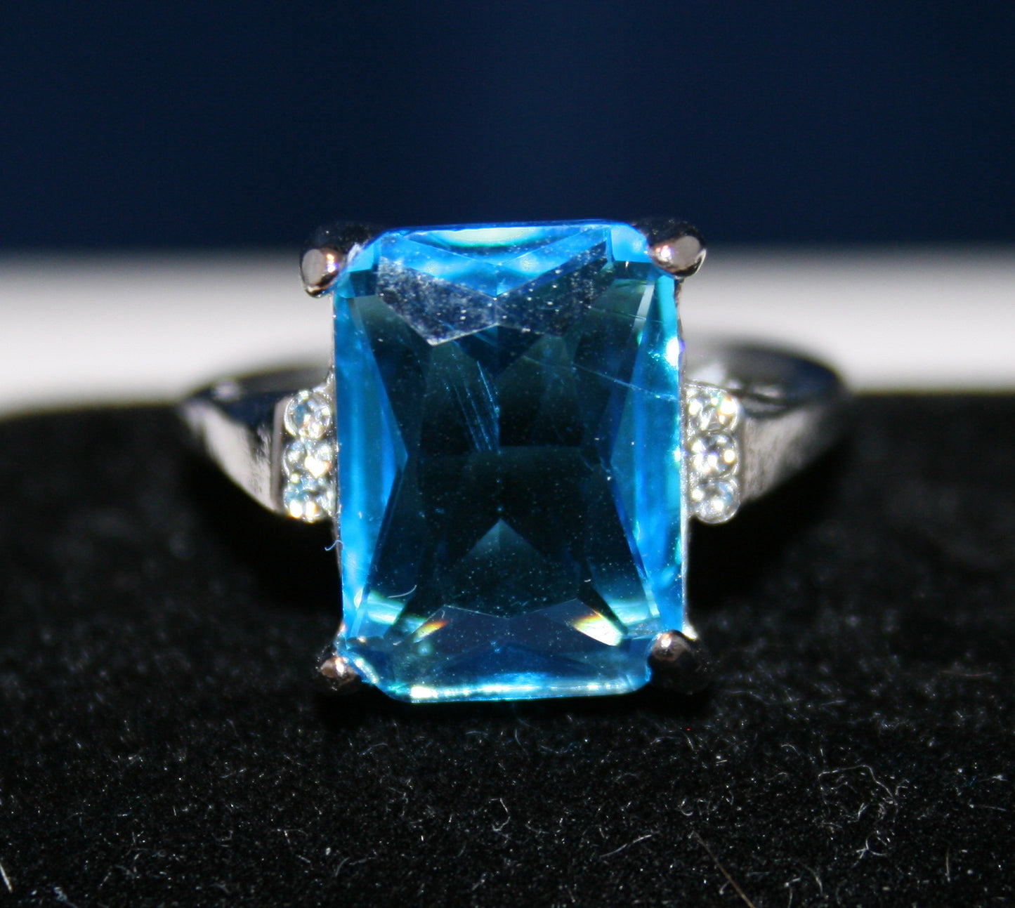 aquamarine rectangular faceted gemstone with accent white stones