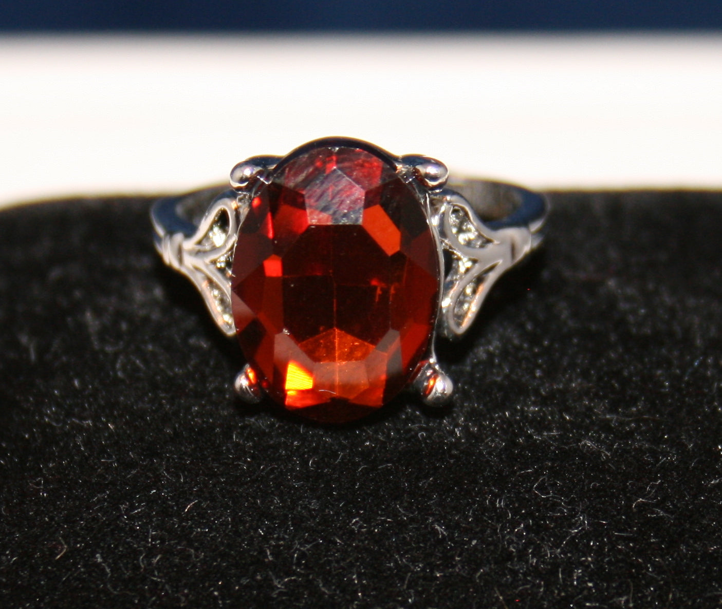 large, oval-shaped, faceted red gemstone