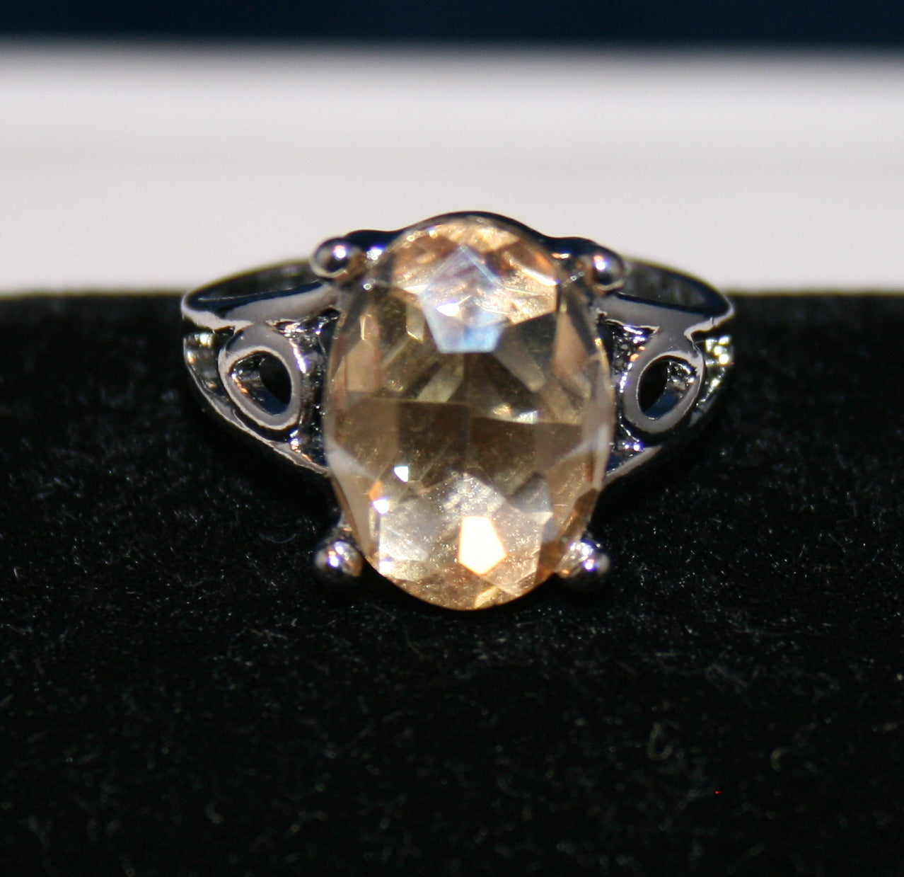 oval-shaped, faceted light yellow or champagne color gemstone