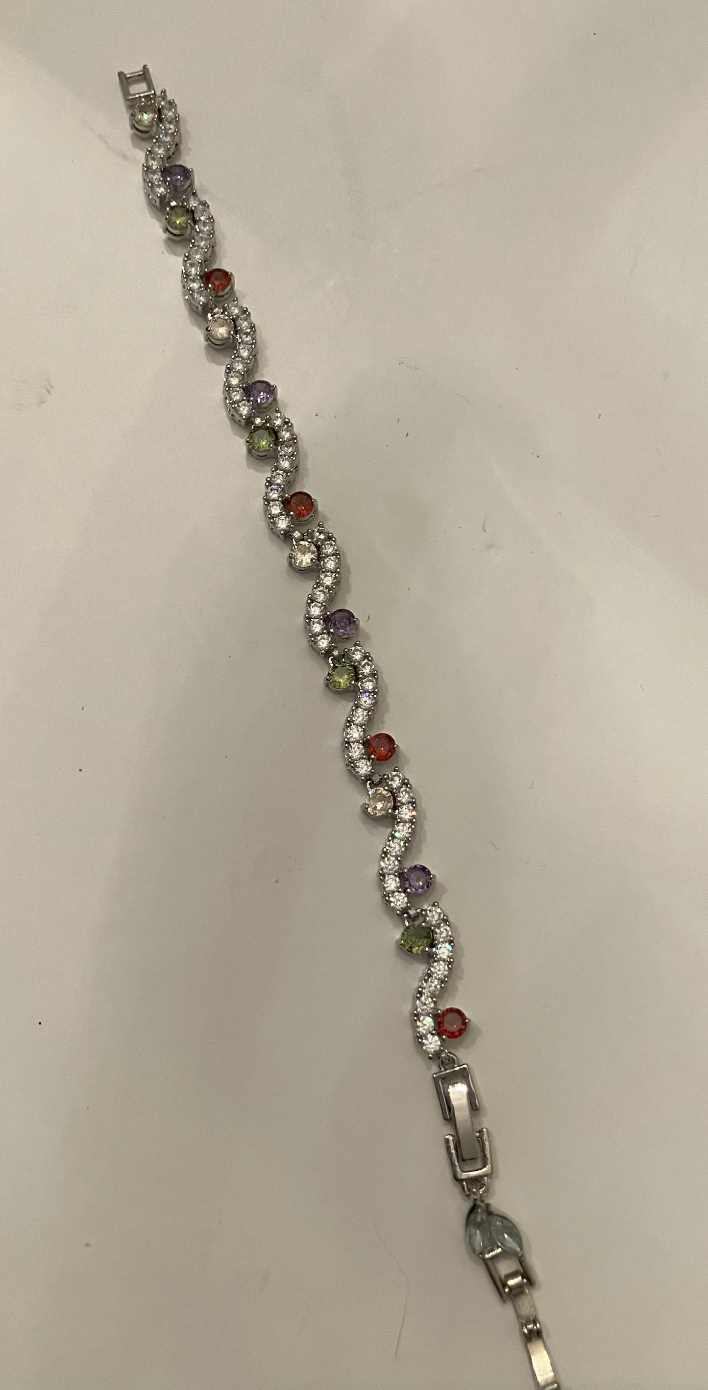 Interlocking link bracelet with clear gemstones and colored gemstone accents