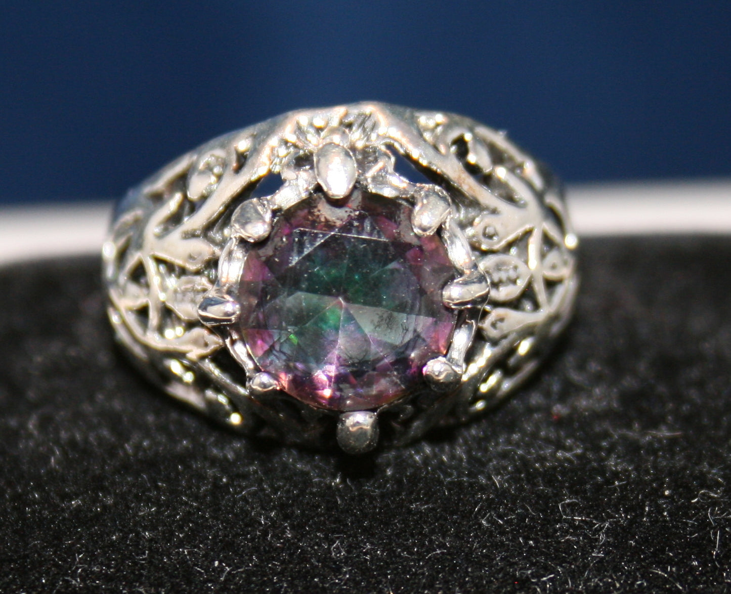 large, multifaceted gemstone with shades of purple, green, and blue.